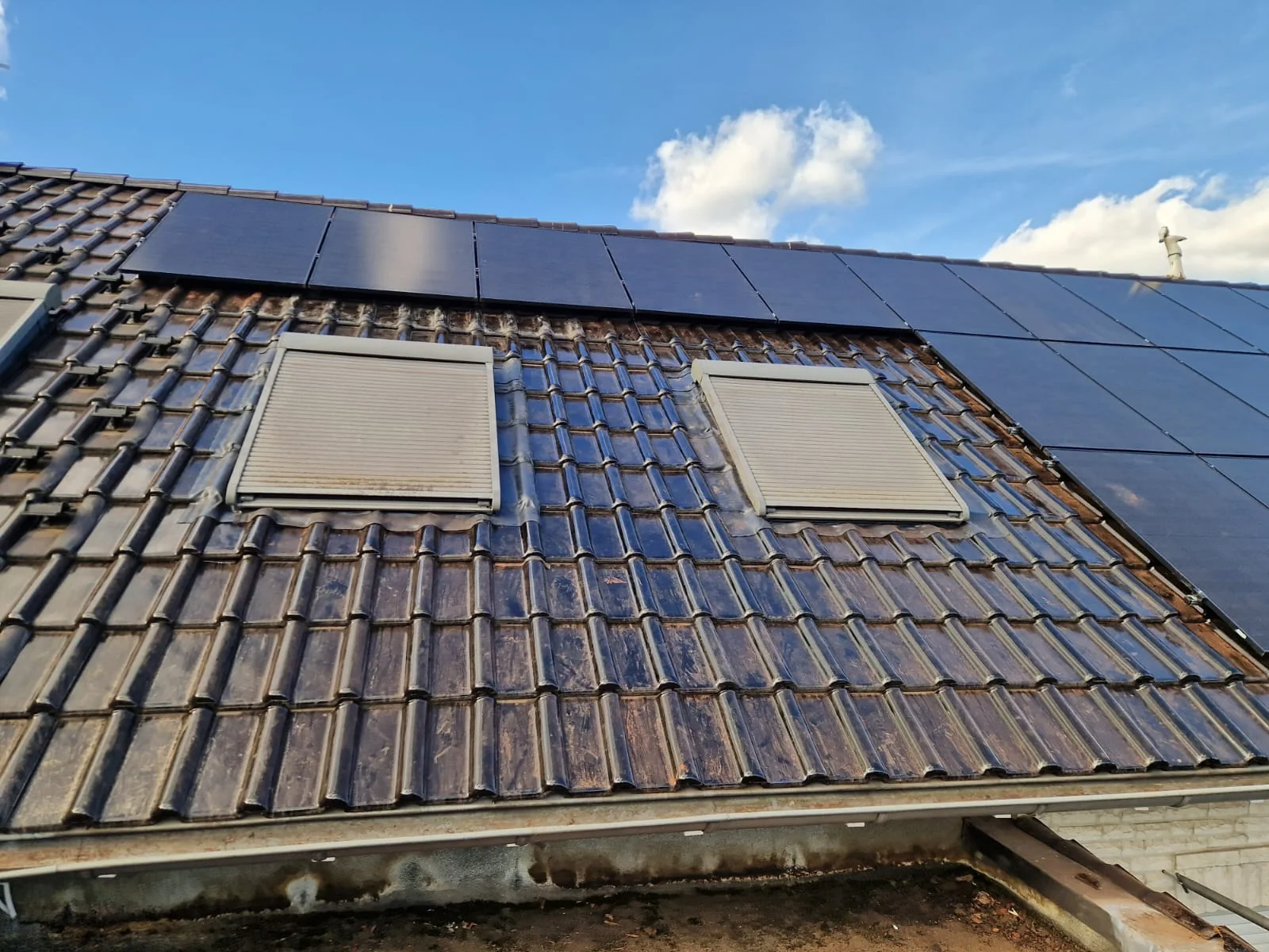 Detailansicht der Solarmodule oberhalb und neben zwei Dachfenstern in Herten