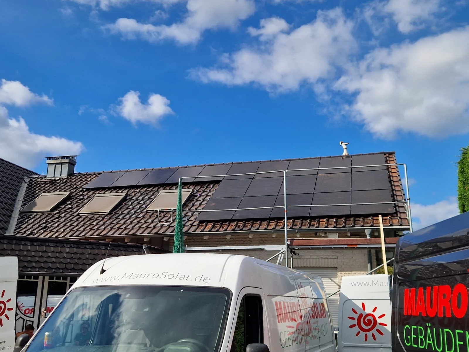 Montierte Photovoltaikanlage in Herten mit Gerüst und Mauro-Solar-Fahrzeugen im Vordergrund